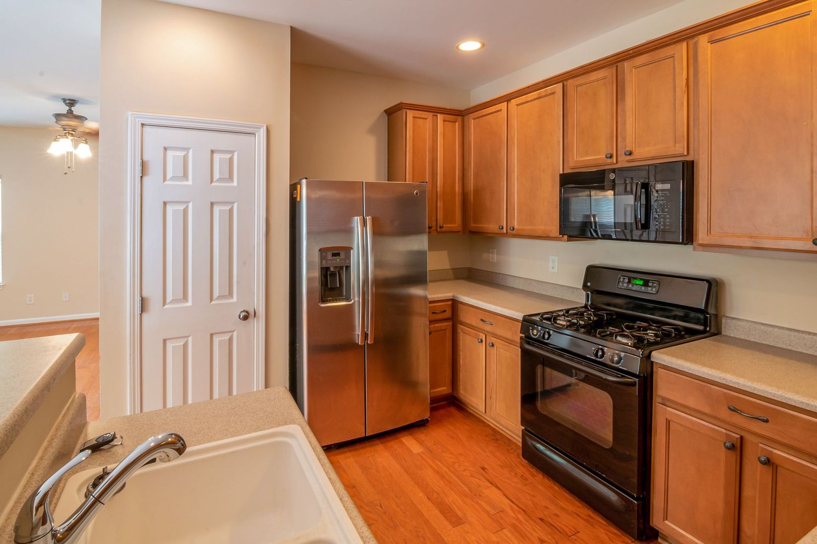 Shared kitchen with an island, stools and full-size appliances